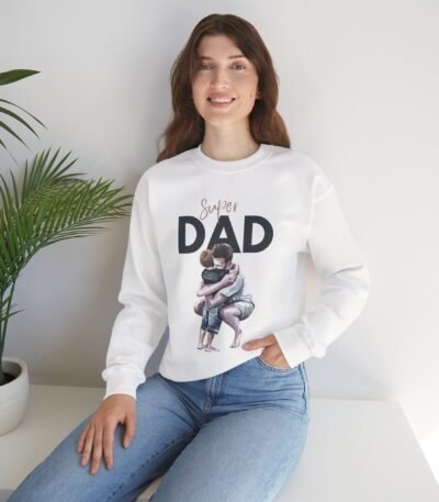 A woman wearing a white Super Dad Crewneck Sweatshirt featuring a sentimental illustration of a father kneeling to hug his child.